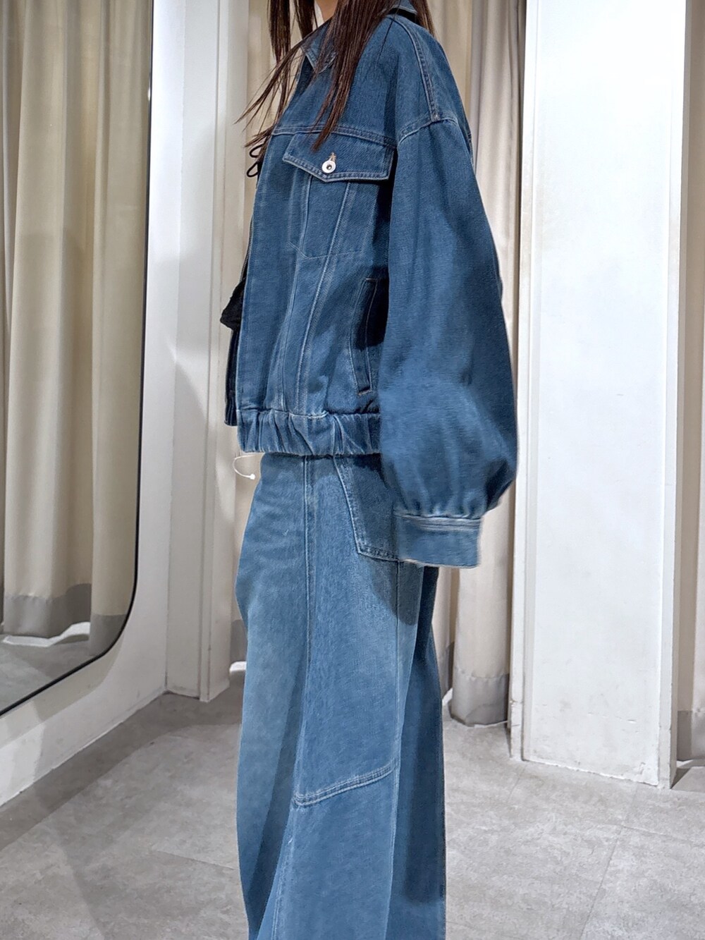 ブルー系のデニムパンツ、ブラック系のシャツ/ブラウス、ブルー系のデニムジャケットを着用したレディースの秋コーディネートの2枚目の写真