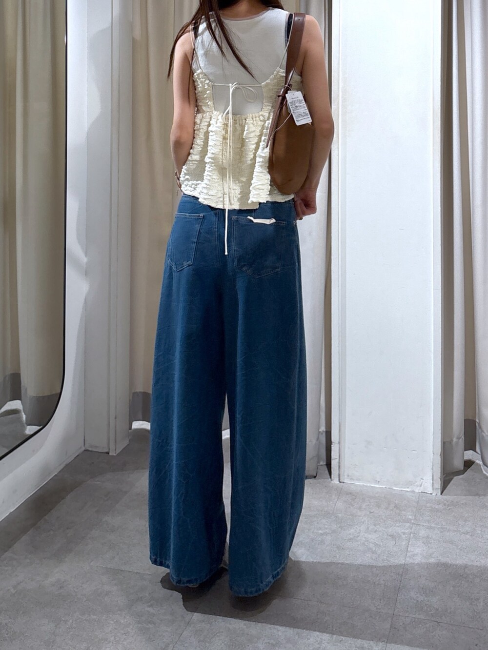 ベージュ系のパンプス、ブルー系のその他パンツ、ブラウン系のハンドバッグを着用したレディースの夏コーディネートの2枚目の写真