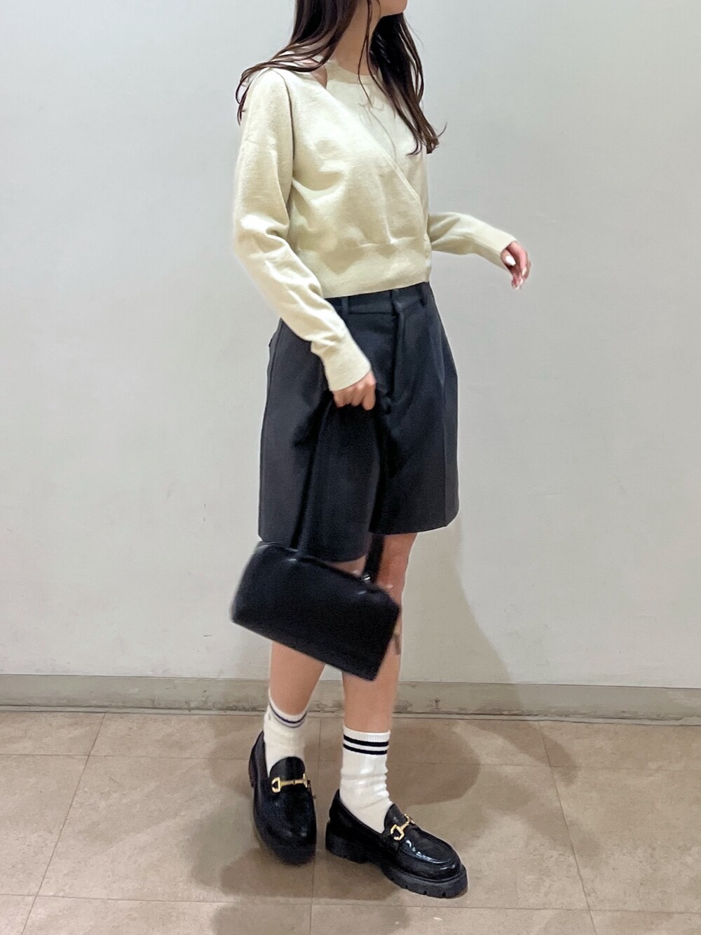 グレー系のその他パンツ、ホワイト系のニット/セーター、ブラック系のショルダーバッグを着用したレディースの冬コーディネートの2枚目の写真