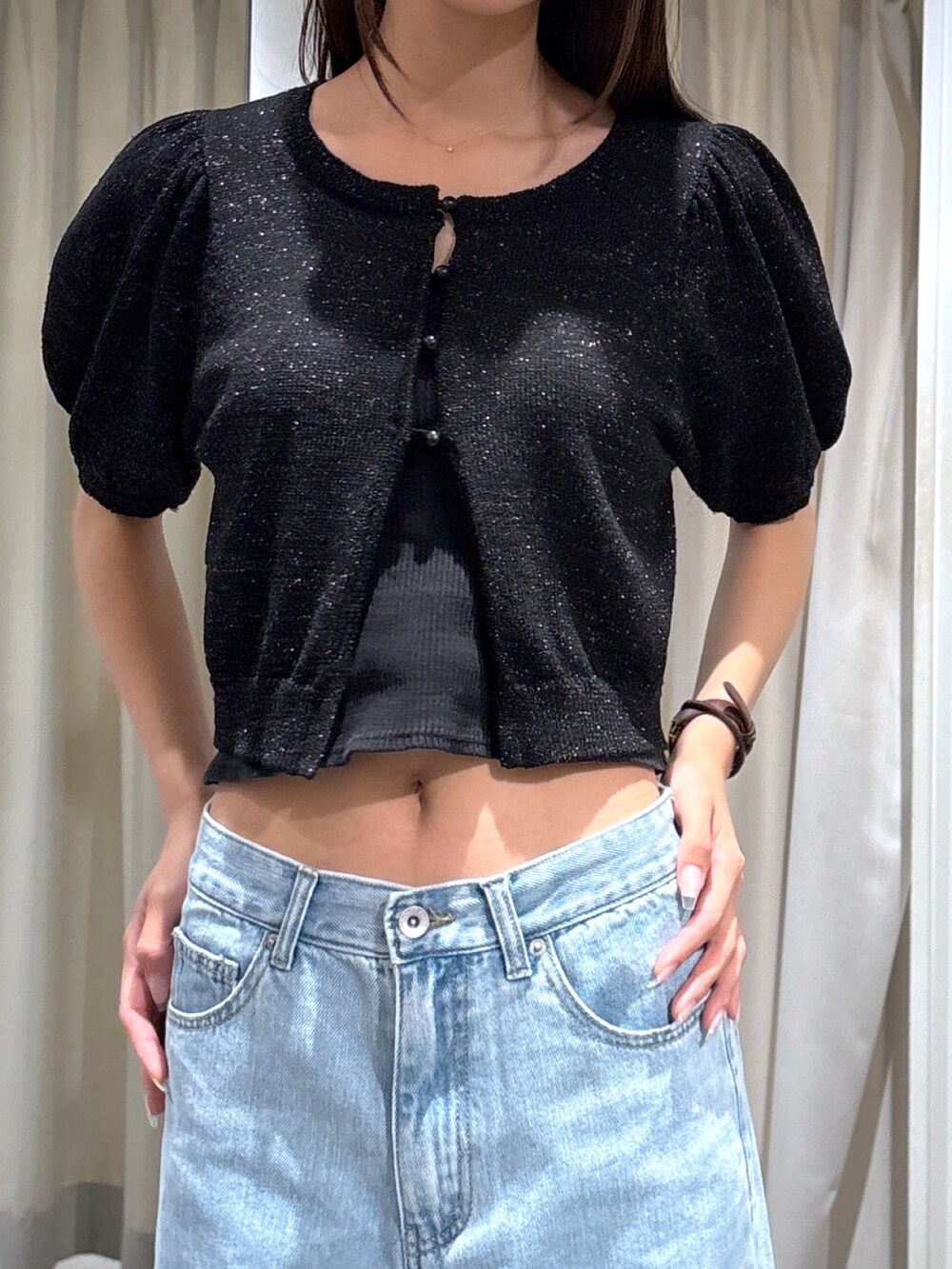 ブルー系のデニムパンツ、ブラック系のカーディガン/ボレロを着用したレディースの夏コーディネートの2枚目の写真