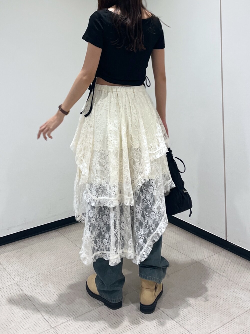 ホワイト系のスカート、ブラック系のハンドバッグ、ブラック系のTシャツ/カットソーを着用したレディースの秋コーディネートの2枚目の写真
