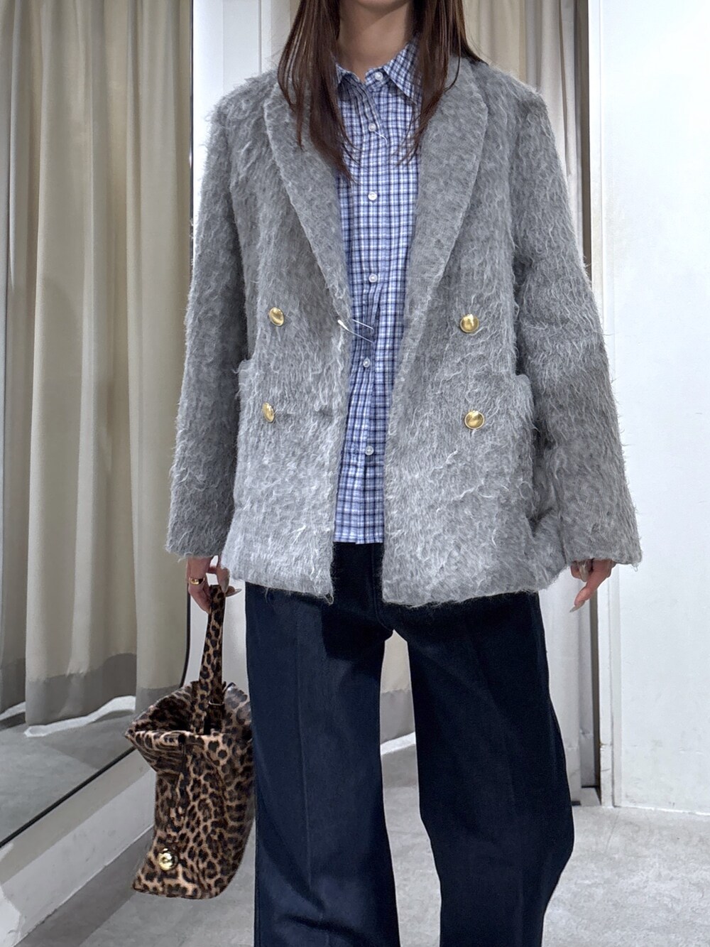 グレー系のテーラードジャケット、ブルー系のシャツ/ブラウス、ブラウン系のショルダーバッグを着用したレディースの冬コーディネートの3枚目の写真