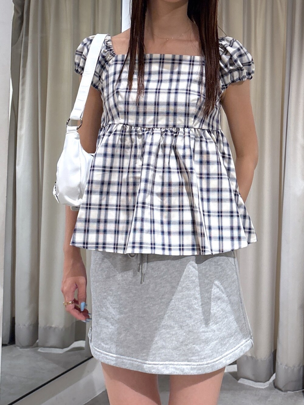 ホワイト系のショルダーバッグ、ブルー系のシャツ/ブラウスを着用したレディースの夏コーディネートの3枚目の写真