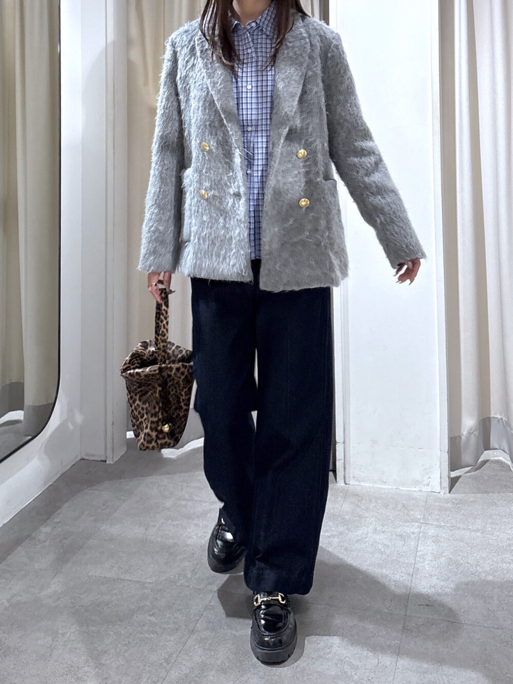 グレー系のテーラードジャケット、ブルー系のシャツ/ブラウス、ブラウン系のショルダーバッグを着用したレディースの冬コーディネートの2枚目の写真