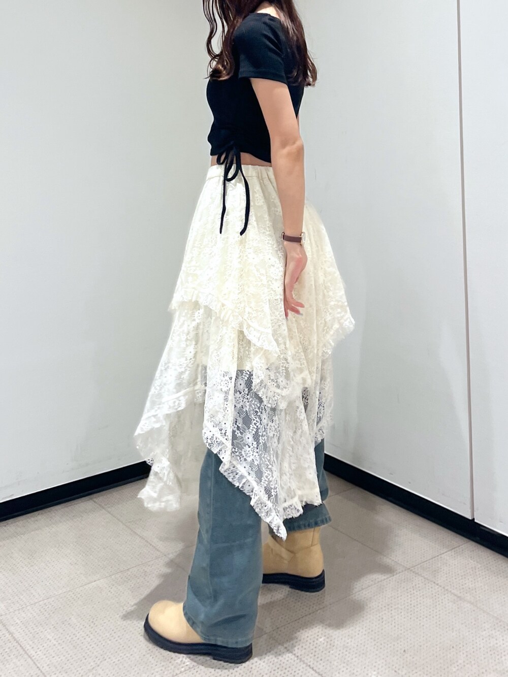 ホワイト系のスカート、ブラック系のハンドバッグ、ブラック系のTシャツ/カットソーを着用したレディースの秋コーディネートの3枚目の写真