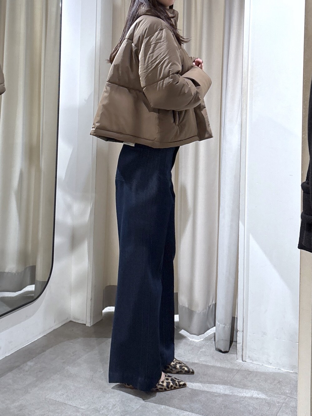 ブルー系のデニムパンツ、ベージュ系のパンプス、ブラウン系のブルゾンを着用したレディースの冬コーディネートの3枚目の写真