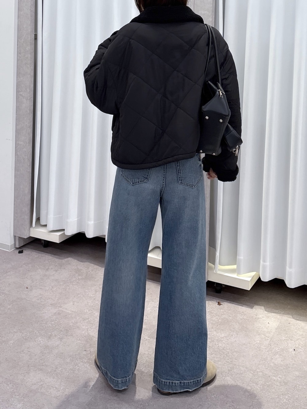 ブルー系のデニムパンツ、ブラウン系のスウェット、ブラック系のブルゾンを着用したレディースの秋コーディネートの3枚目の写真