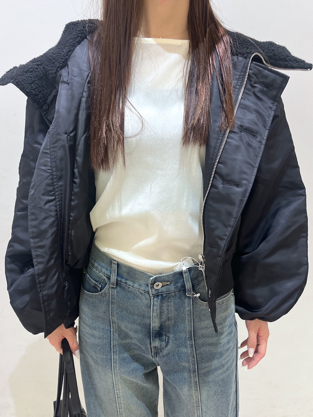 ブルー系のデニムパンツ、ホワイト系のTシャツ/カットソー、ブラック系のブルゾンを着用したレディースの冬コーディネートの3枚目の写真