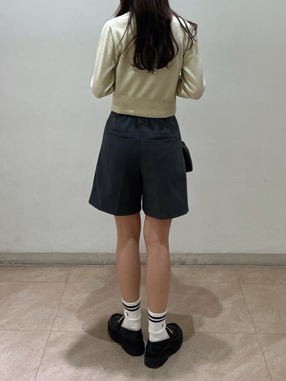 グレー系のその他パンツ、ホワイト系のニット/セーター、ブラック系のショルダーバッグを着用したレディースの冬コーディネートの3枚目の写真