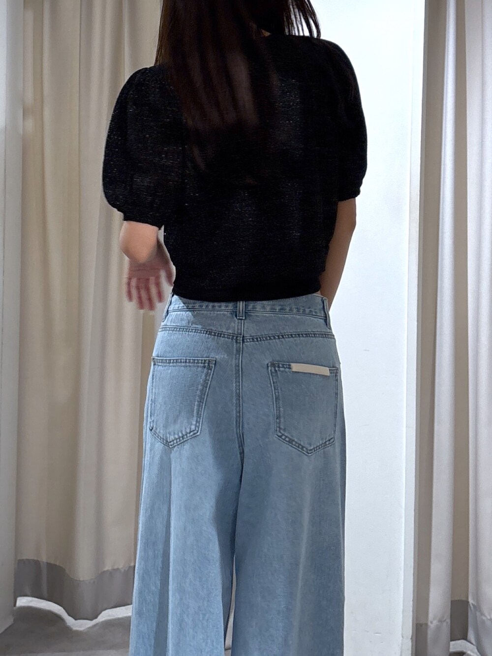 ブルー系のデニムパンツ、ブラック系のカーディガン/ボレロを着用したレディースの夏コーディネートの3枚目の写真