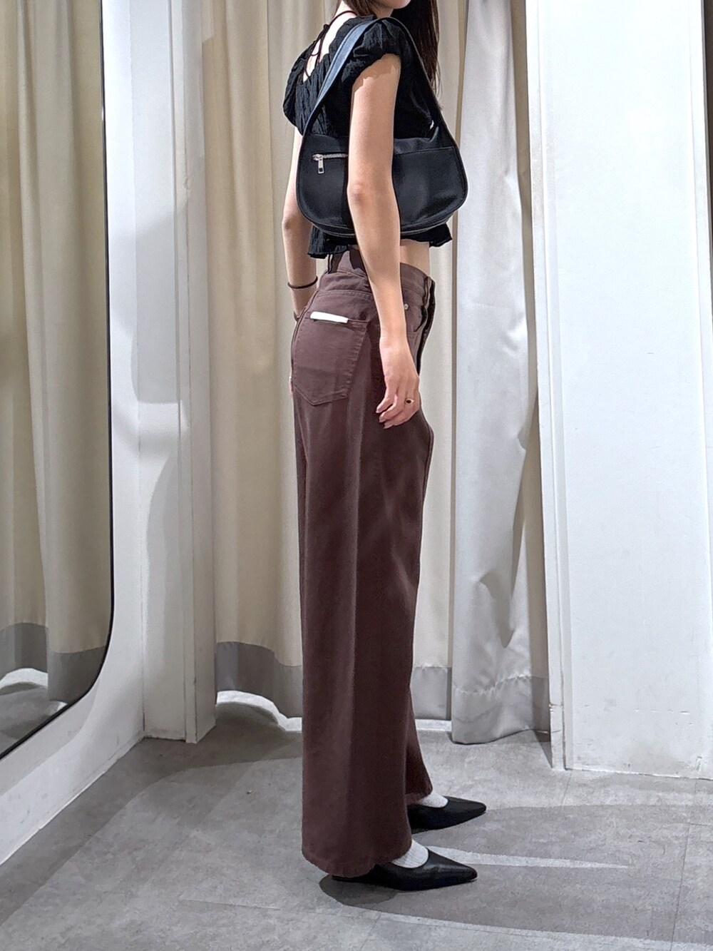 ブラウン系のデニムパンツ、ブラック系のハンドバッグ、ブラック系のシャツ/ブラウスを着用したレディースの夏コーディネートの2枚目の写真