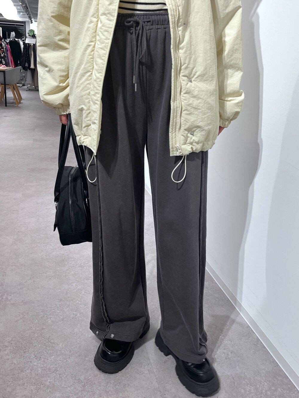 ホワイト系のニット/セーター、ホワイト系のダウンジャケット/コート、グレー系のスウェットパンツを着用したレディースの秋コーディネートの3枚目の写真
