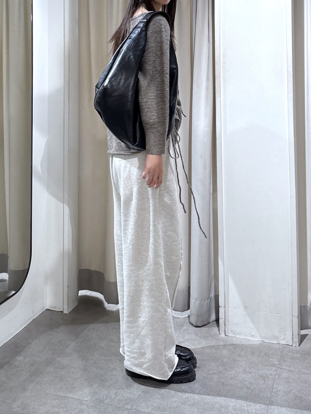 ホワイト系のスウェットパンツ、ブラウン系のトートバッグ、ブラウン系のニット/セーターを着用したレディースの冬コーディネートの2枚目の写真