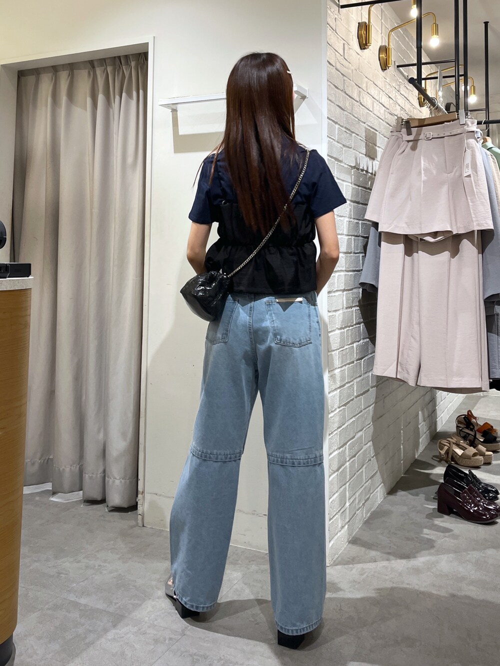 シルバー系のパンプス、ブルー系のデニムパンツ、ブルー系のTシャツ/カットソーを着用したレディースの夏コーディネートの2枚目の写真