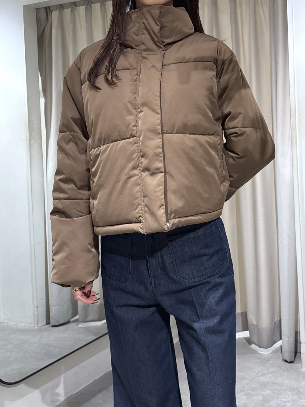 ブルー系のデニムパンツ、ベージュ系のパンプス、ブラウン系のブルゾンを着用したレディースの冬コーディネートの2枚目の写真