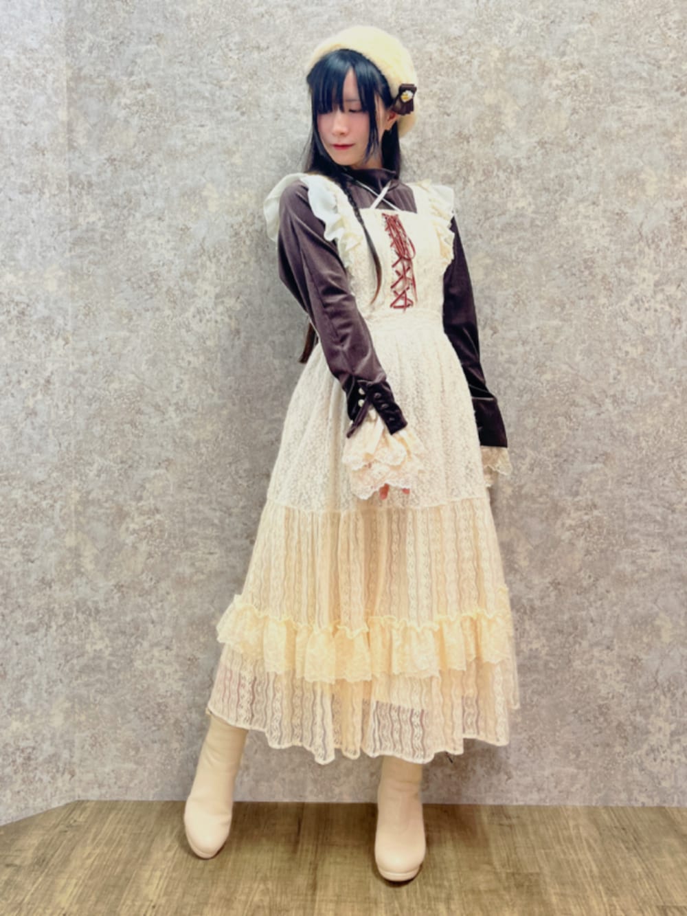 ベージュ系のブーツ、ブラウン系のTシャツ/カットソー、ホワイト系のジャンパースカートを着用したレディースの秋コーディネートの2枚目の写真