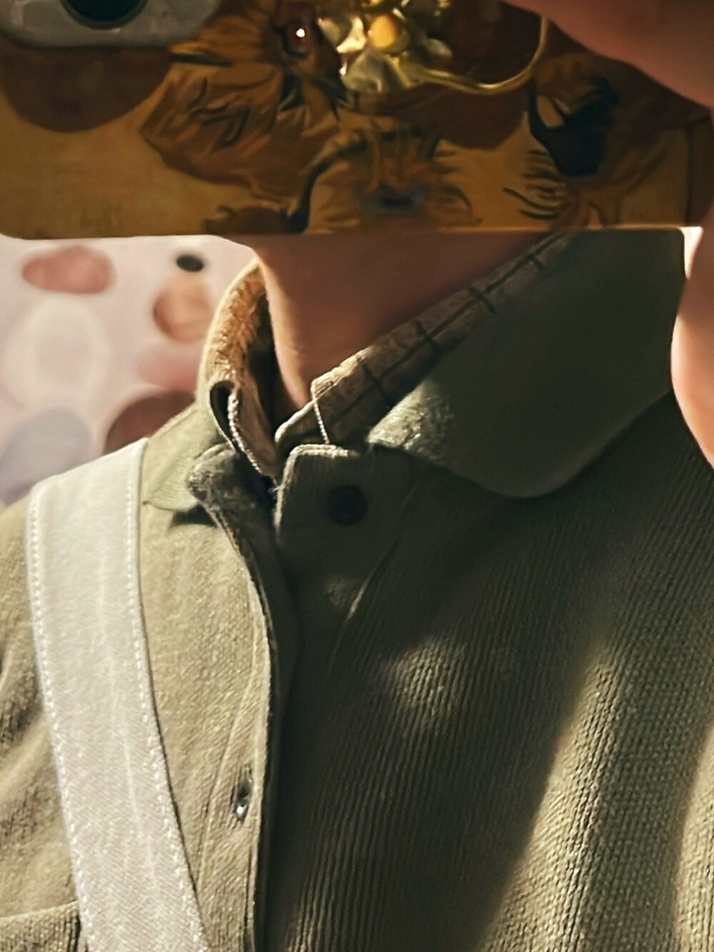 ブラウン系のスラックス、ベージュ系のポロシャツ、グリーン系のキャップを着用したメンズの春コーディネートの2枚目の写真