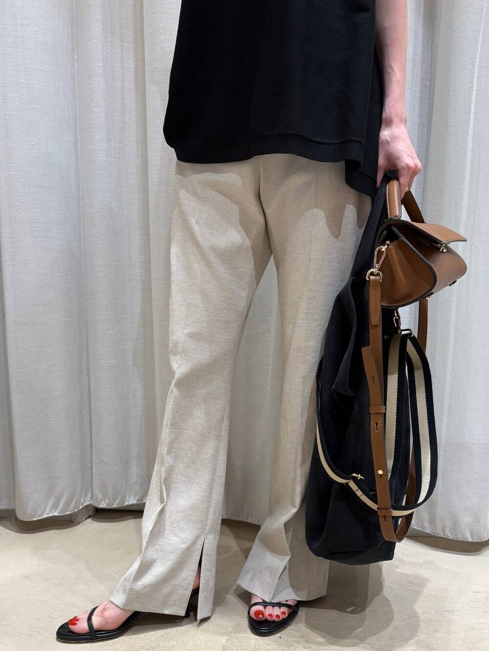 ブラック系のトートバッグ、ベージュ系のその他パンツ、ブラック系のニット/セーターを着用したレディースの春コーディネートの4枚目の写真