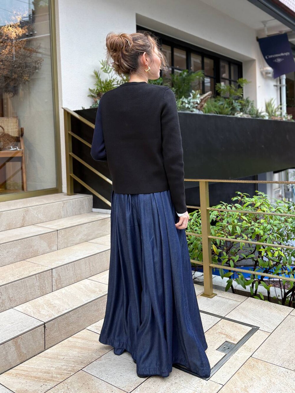 ブルー系のデニムパンツ、ゴールド系のピアス(両耳用)を着用したレディースの秋コーディネートの3枚目の写真