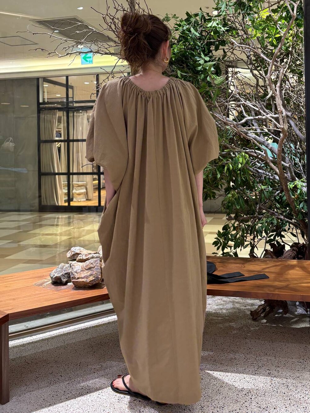 ベージュ系のワンピース、ゴールド系のピアス（両耳用）を着用したレディースの夏コーディネートの3枚目の写真