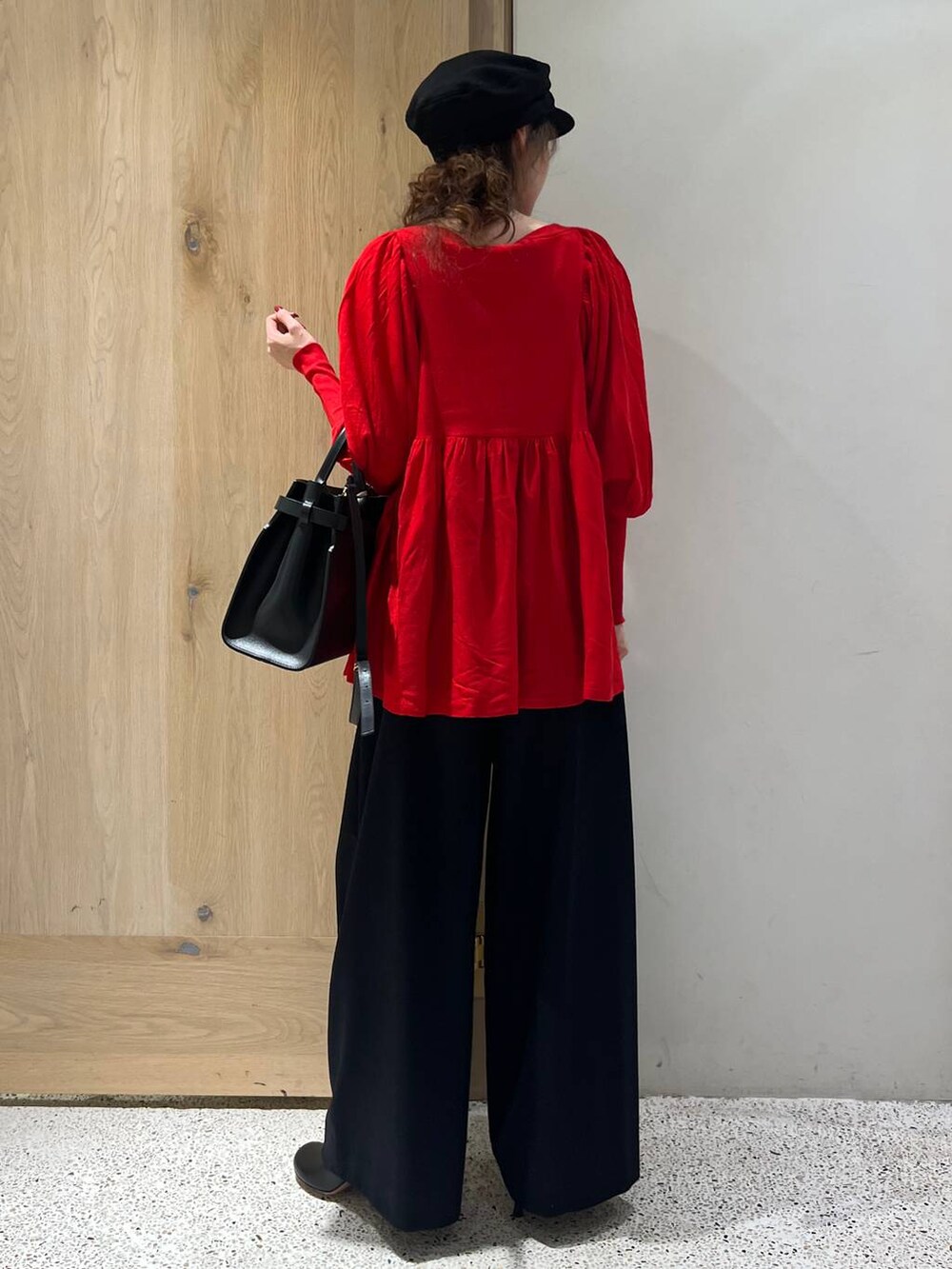 ブルー系のその他パンツ、レッド系のニット/セーター、ブラック系のトートバッグを着用したレディースの秋コーディネートの3枚目の写真