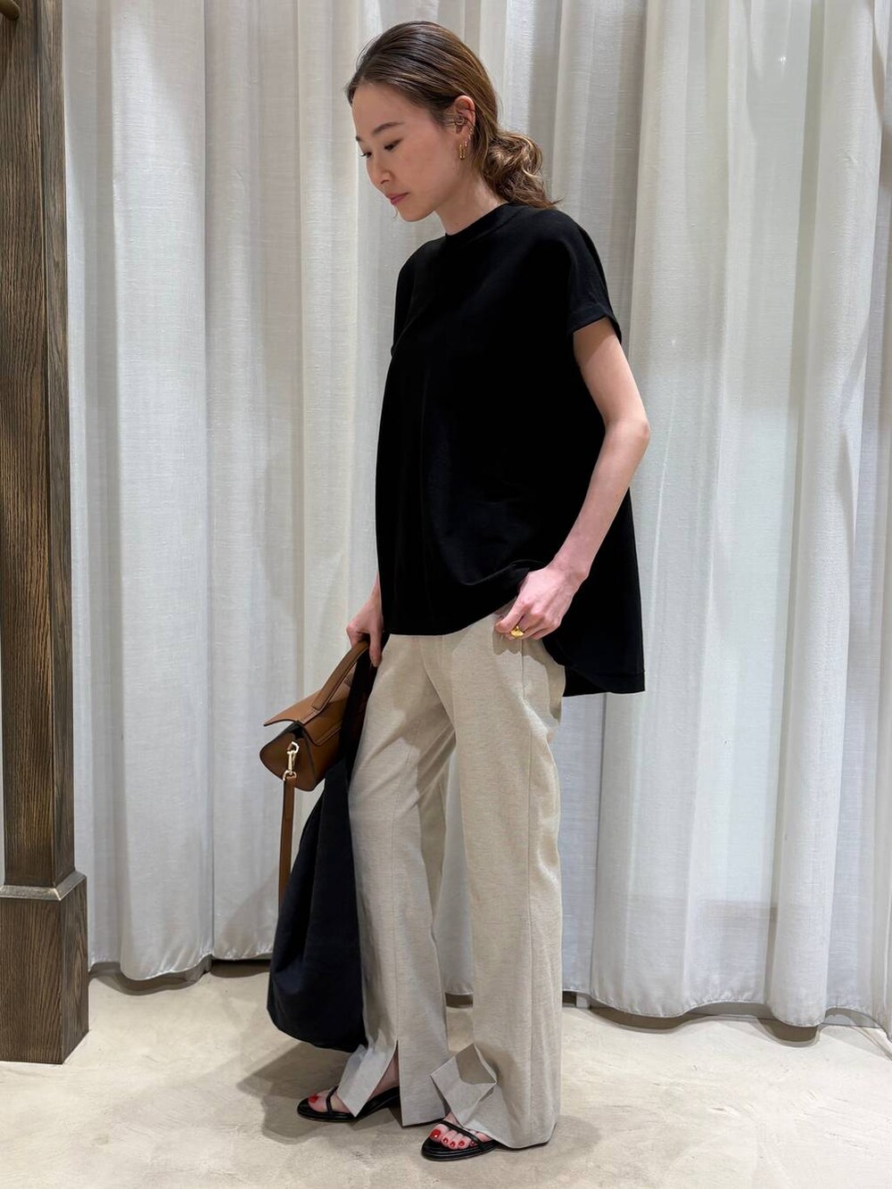ブラック系のトートバッグ、ベージュ系のその他パンツ、ブラック系のニット/セーターを着用したレディースの春コーディネートの2枚目の写真