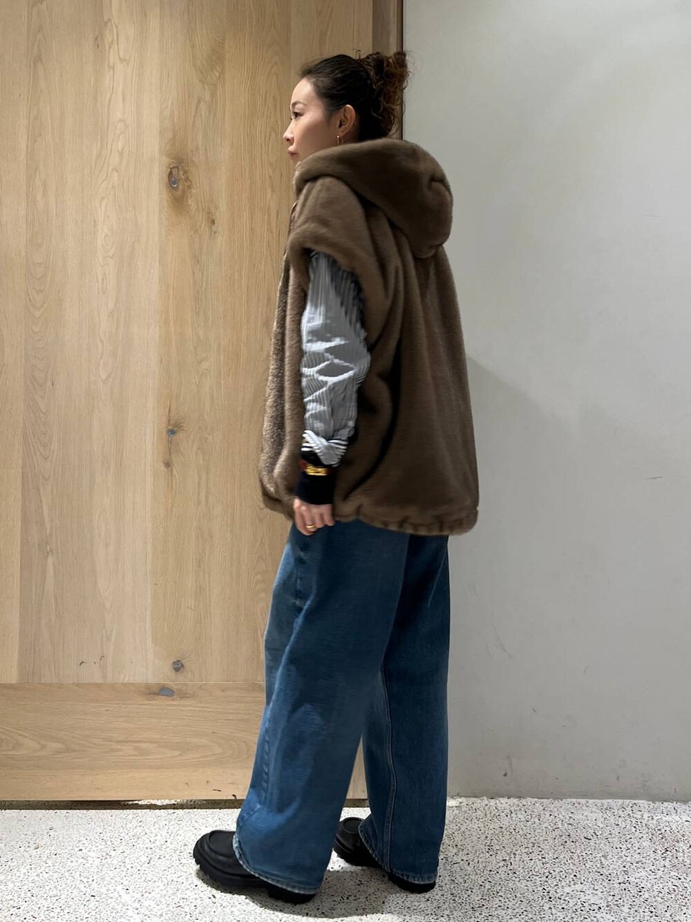 ブルー系のデニムパンツ、ブラック系のニット/セーター、ブルー系のシャツ/ブラウスを着用したレディースの秋コーディネートの3枚目の写真