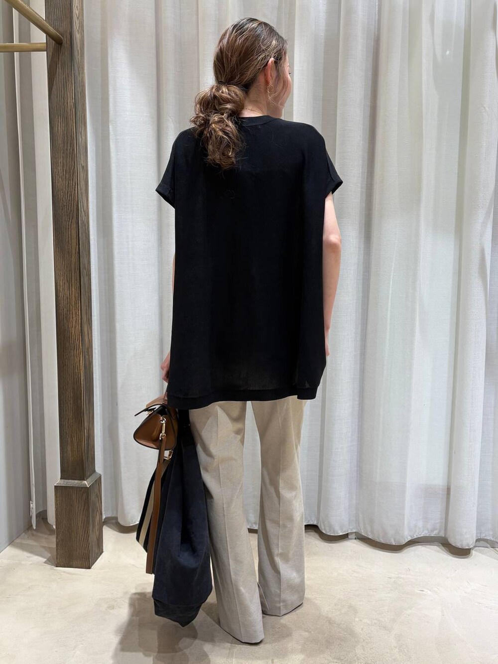 ブラック系のトートバッグ、ベージュ系のその他パンツ、ブラック系のニット/セーターを着用したレディースの春コーディネートの3枚目の写真