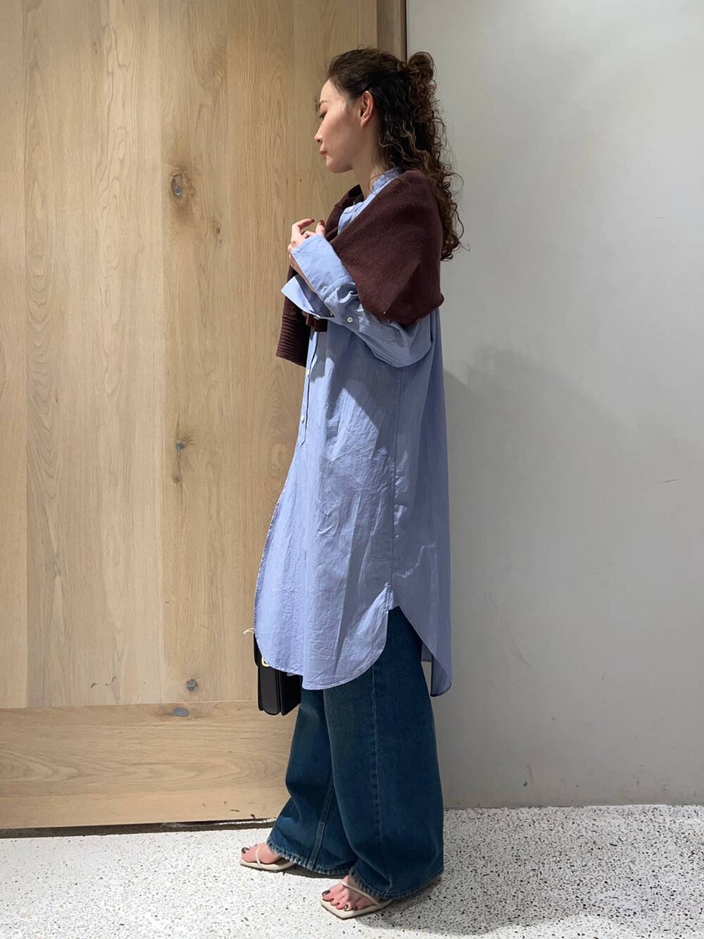 ブラウン系のニット/セーター、ホワイト系のサンダル、ブルー系のデニムパンツを着用したレディースの夏コーディネートの2枚目の写真