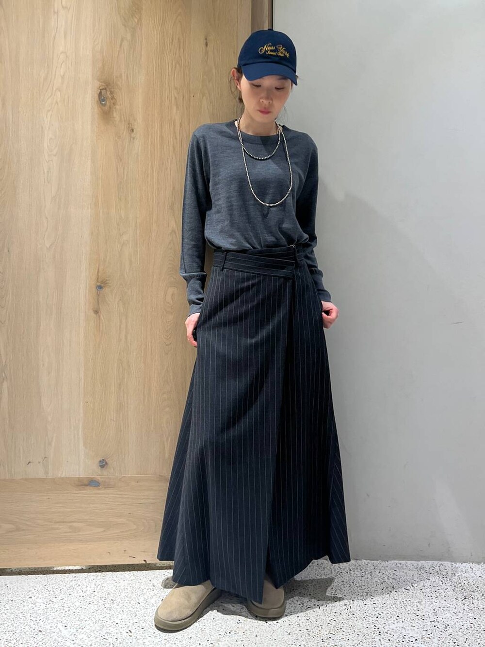 ブラウン系のベスト、グレー系のニット/セーター、グレー系のスカートを着用したレディースの秋コーディネートの2枚目の写真