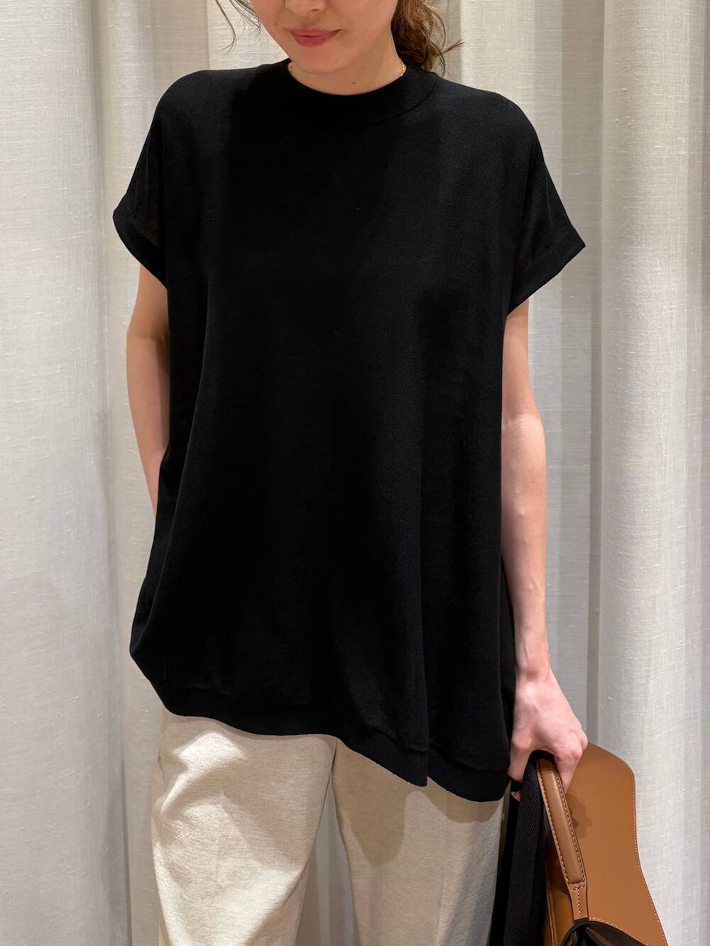 ブラック系のトートバッグ、ベージュ系のその他パンツ、ブラック系のニット/セーターを着用したレディースの春コーディネートの5枚目の写真