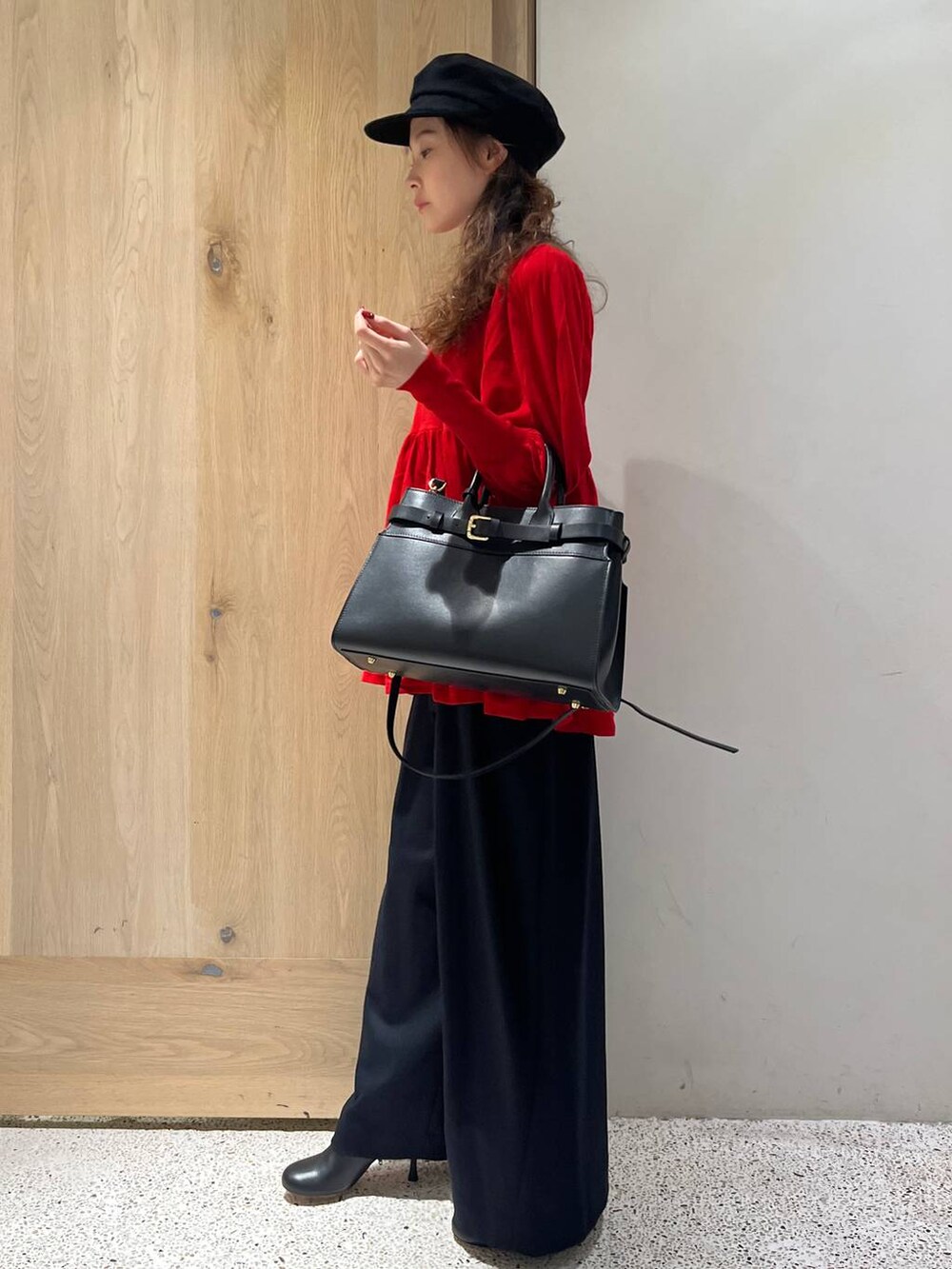 ブルー系のその他パンツ、レッド系のニット/セーター、ブラック系のトートバッグを着用したレディースの秋コーディネートの2枚目の写真