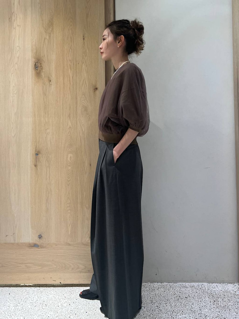 ブラウン系のニット/セーター、グレー系のその他パンツを着用したレディースの春コーディネートの2枚目の写真
