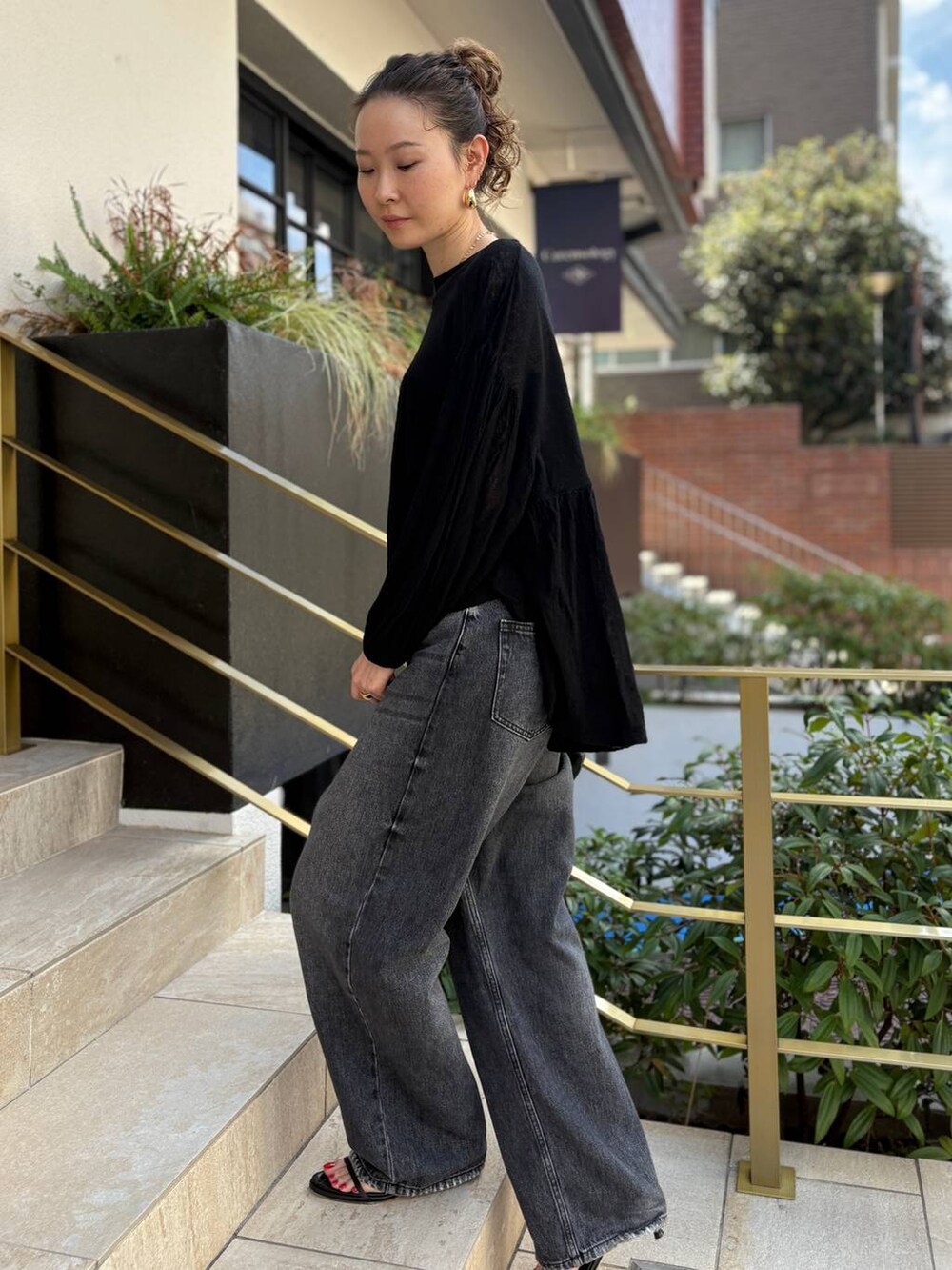 ブラック系のデニムパンツ、ブラック系のクラッチバッグ、ブラック系のニット/セーターを着用したレディースの秋コーディネートの5枚目の写真