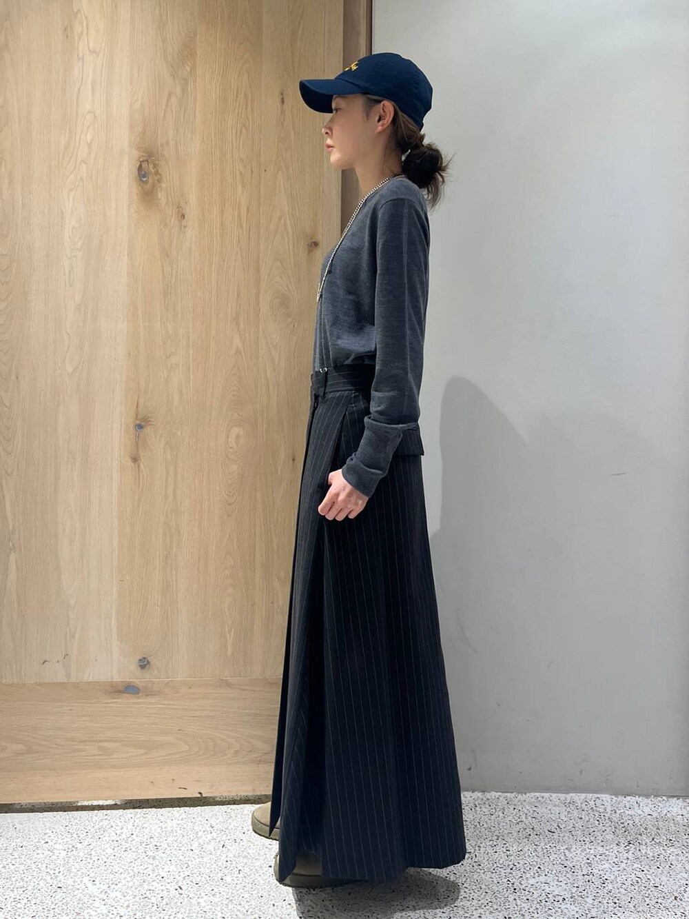 ブラウン系のベスト、グレー系のニット/セーター、グレー系のスカートを着用したレディースの秋コーディネートの3枚目の写真