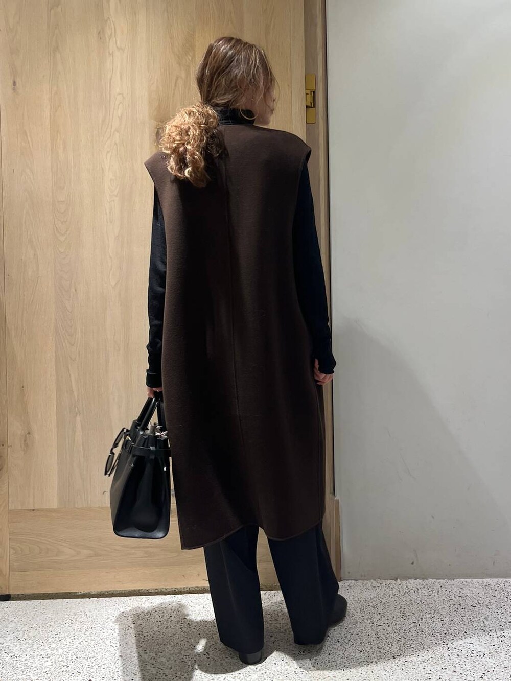 ブラウン系のベスト、ブラック系のニット/セーター、ブラック系のその他パンツを着用したレディースの冬コーディネートの3枚目の写真