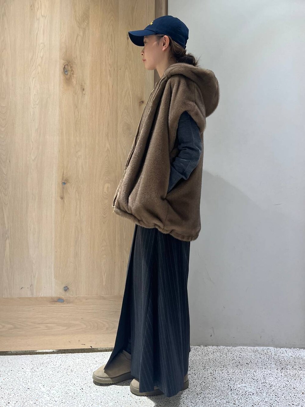 ブラウン系のベスト、グレー系のニット/セーター、グレー系のスカートを着用したレディースの秋コーディネートの2枚目の写真