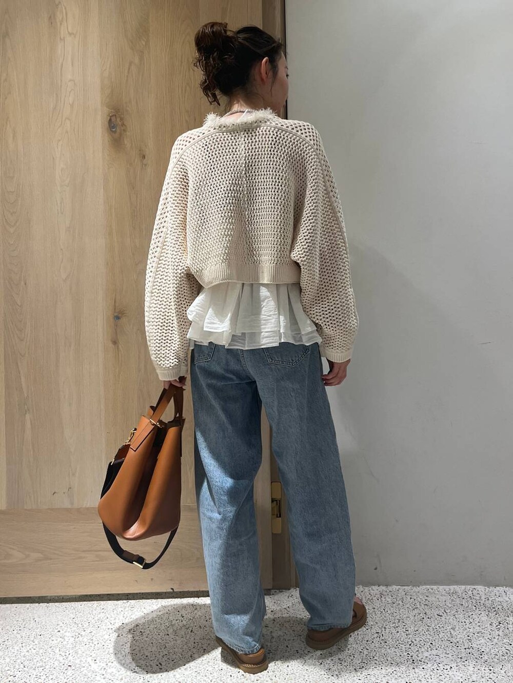 ベージュ系のカーディガン/ボレロ、ホワイト系のキャミソール、ブルー系のデニムパンツを着用したレディースの春コーディネートの3枚目の写真
