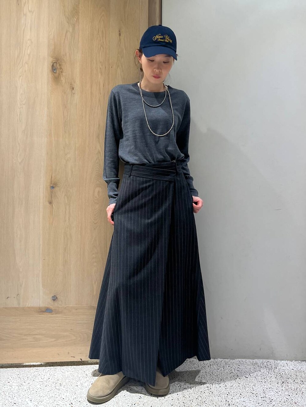 ブラウン系のベスト、グレー系のニット/セーター、グレー系のスカートを着用したレディースの秋コーディネートの4枚目の写真