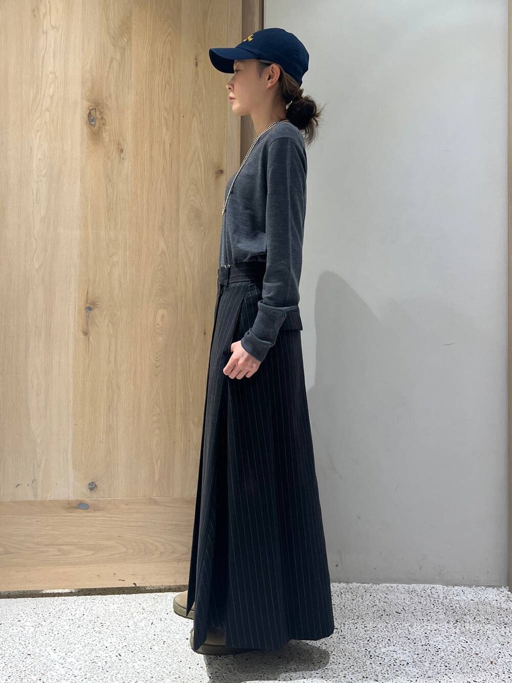 ブラウン系のベスト、グレー系のニット/セーター、グレー系のスカートを着用したレディースの秋コーディネートの5枚目の写真