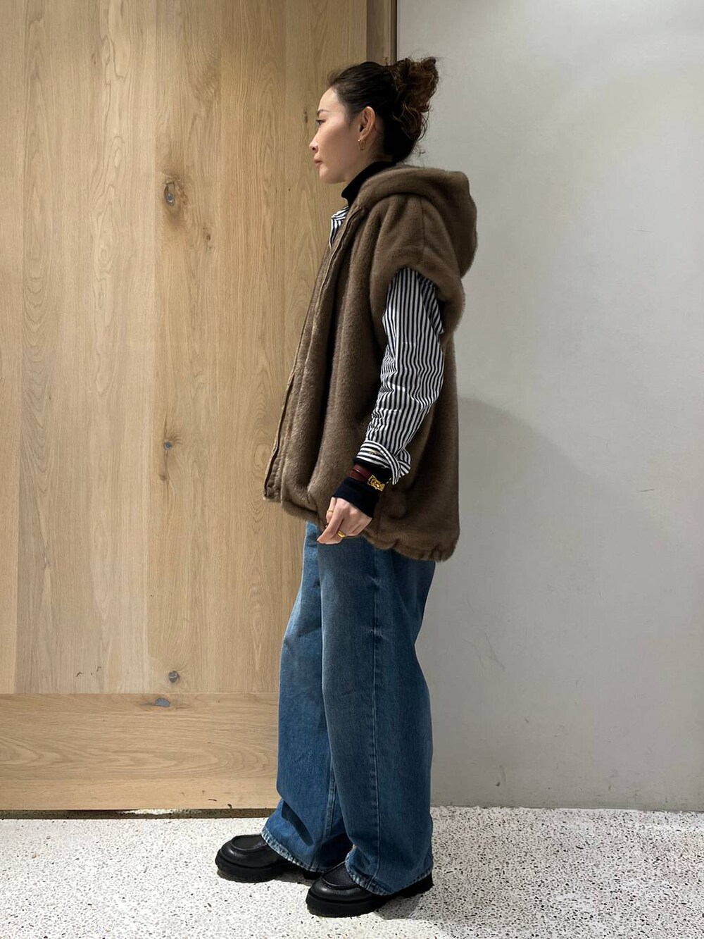 ブルー系のデニムパンツ、ブラック系のニット/セーター、ブルー系のシャツ/ブラウスを着用したレディースの秋コーディネートの2枚目の写真