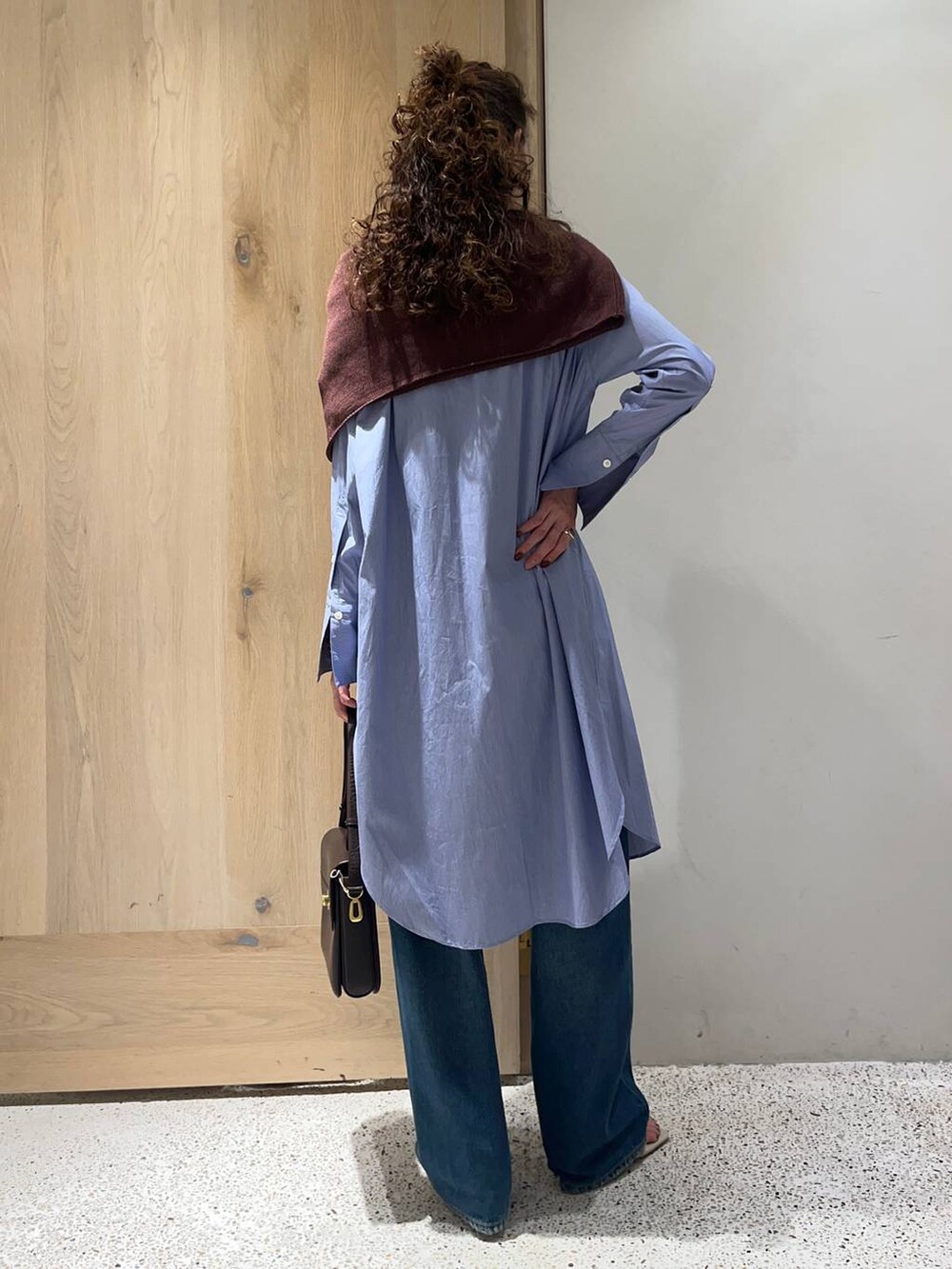 ブラウン系のニット/セーター、ホワイト系のサンダル、ブルー系のデニムパンツを着用したレディースの夏コーディネートの3枚目の写真