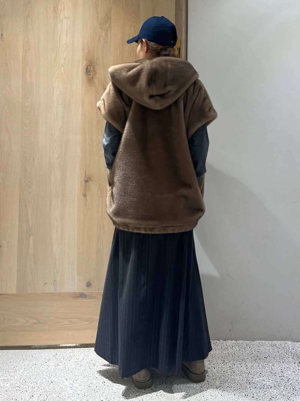 ブラウン系のベスト、グレー系のニット/セーター、グレー系のスカートを着用したレディースの秋コーディネートの3枚目の写真