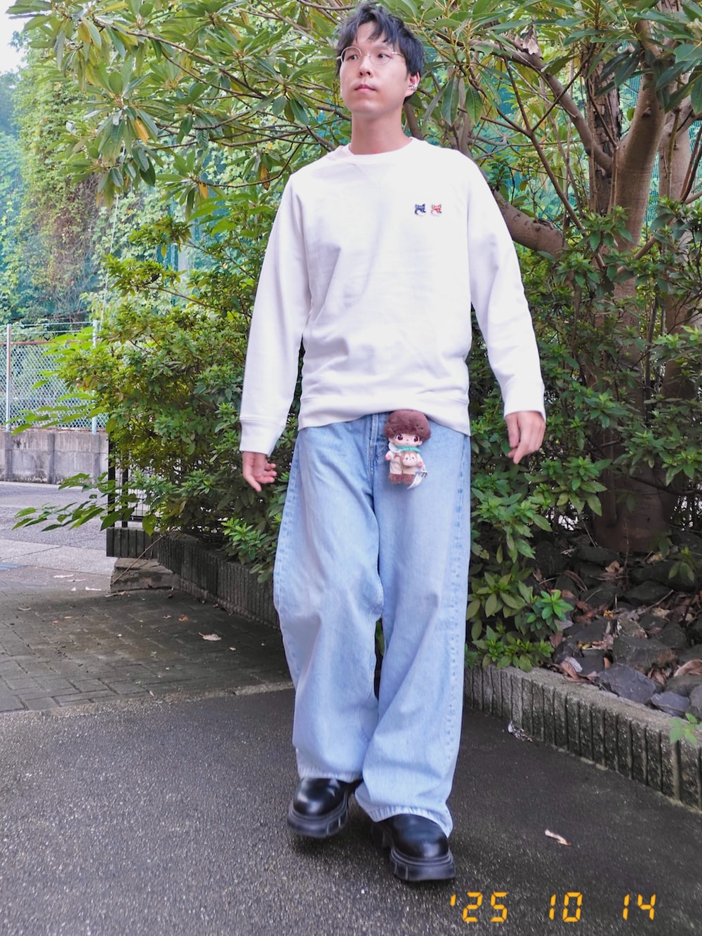 ホワイト系のスウェット、ブルー系のデニムパンツ、ブラック系のブーツを着用したメンズの秋コーディネートの2枚目の写真