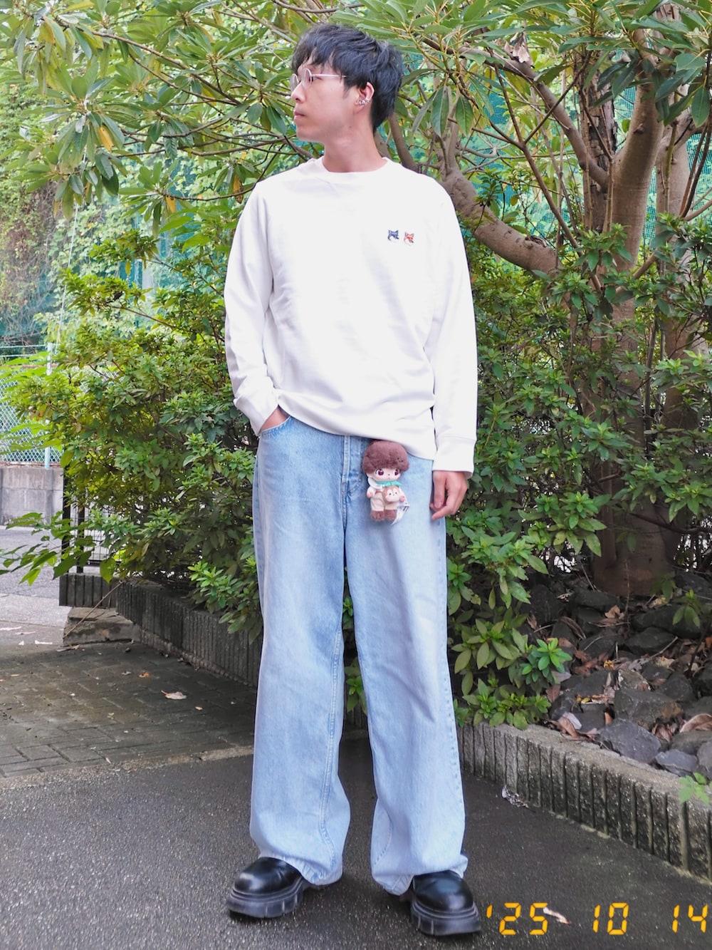 ホワイト系のスウェット、ブルー系のデニムパンツ、ブラック系のブーツを着用したメンズの秋コーディネートの3枚目の写真