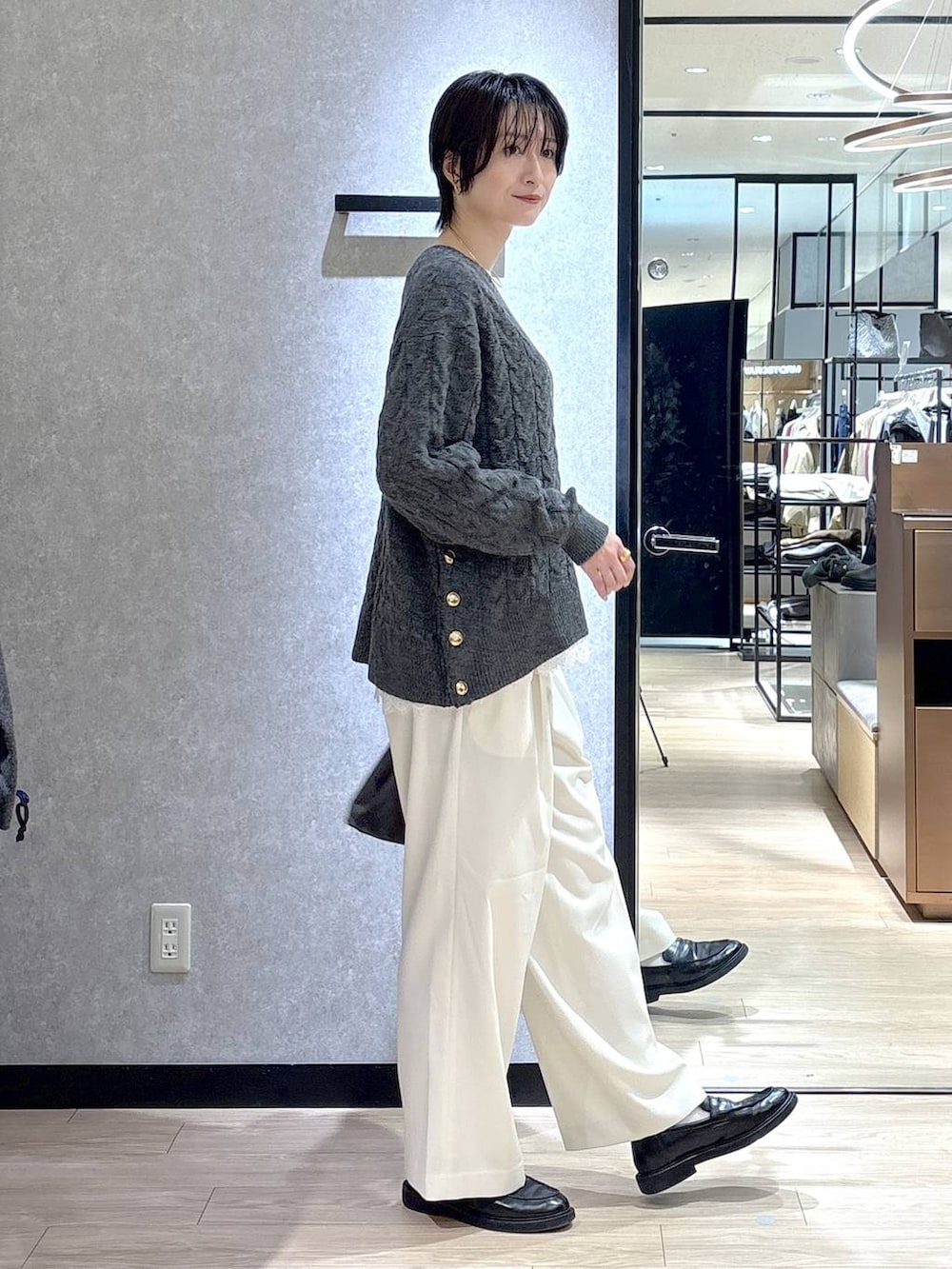 ホワイト系のシャツ/ブラウス、グレー系のニット/セーター、ホワイト系のその他パンツを着用したレディースの冬コーディネートの2枚目の写真