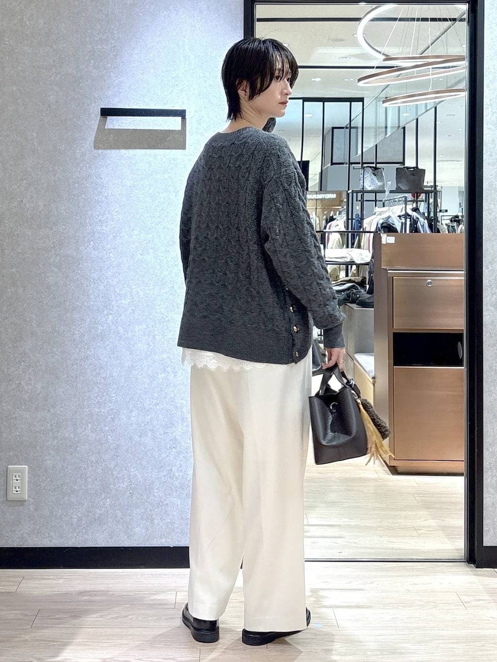 ホワイト系のシャツ/ブラウス、グレー系のニット/セーター、ホワイト系のその他パンツを着用したレディースの冬コーディネートの3枚目の写真