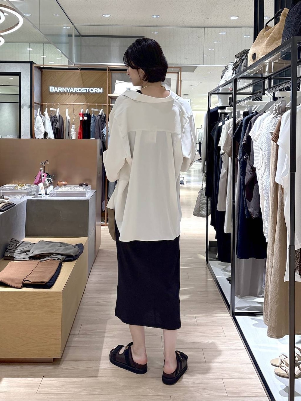 ホワイト系のシャツ/ブラウス、ベージュ系のショルダーバッグ、ブラウン系のサンダルを着用したレディースの夏コーディネートの3枚目の写真