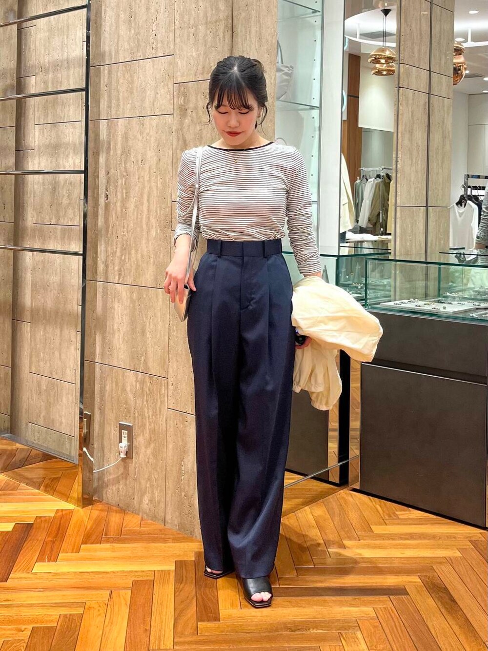 ホワイト系のブルゾン、ブルー系のその他パンツ、ブラック系のTシャツ/カットソーを着用したレディースの春コーディネートの6枚目の写真
