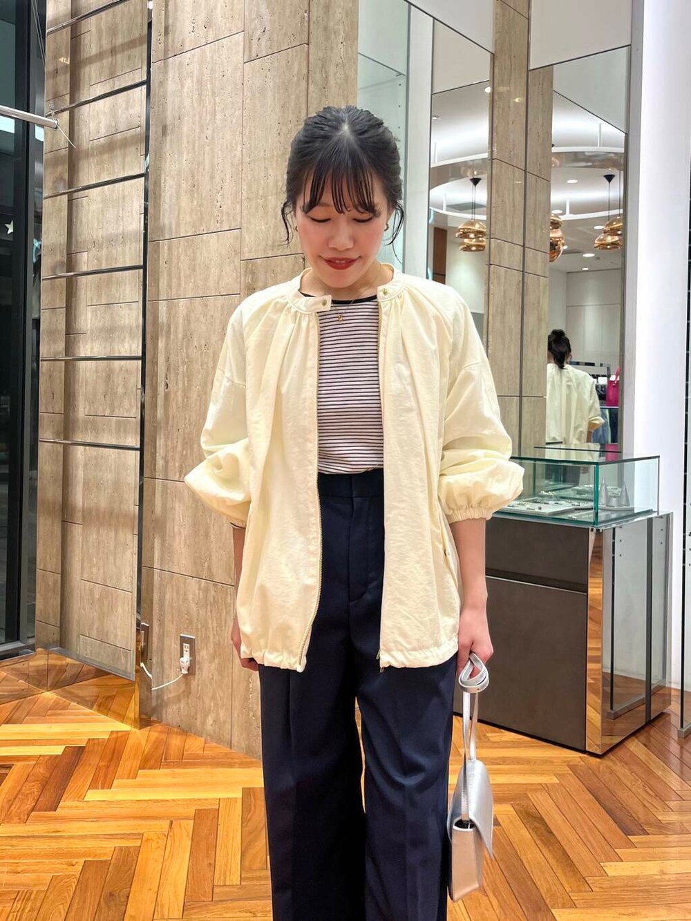 ホワイト系のブルゾン、ブルー系のその他パンツ、ブラック系のTシャツ/カットソーを着用したレディースの春コーディネートの4枚目の写真